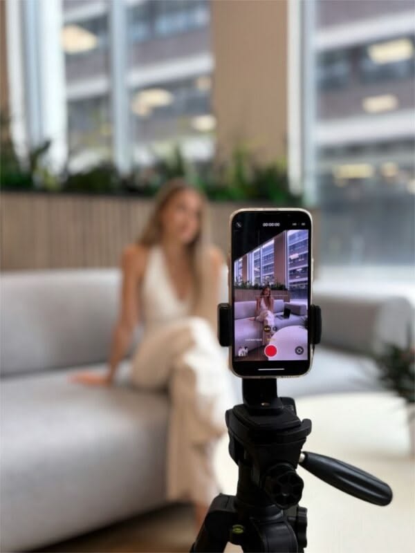 Creadora grabando un video con un teléfono montado en un trípode